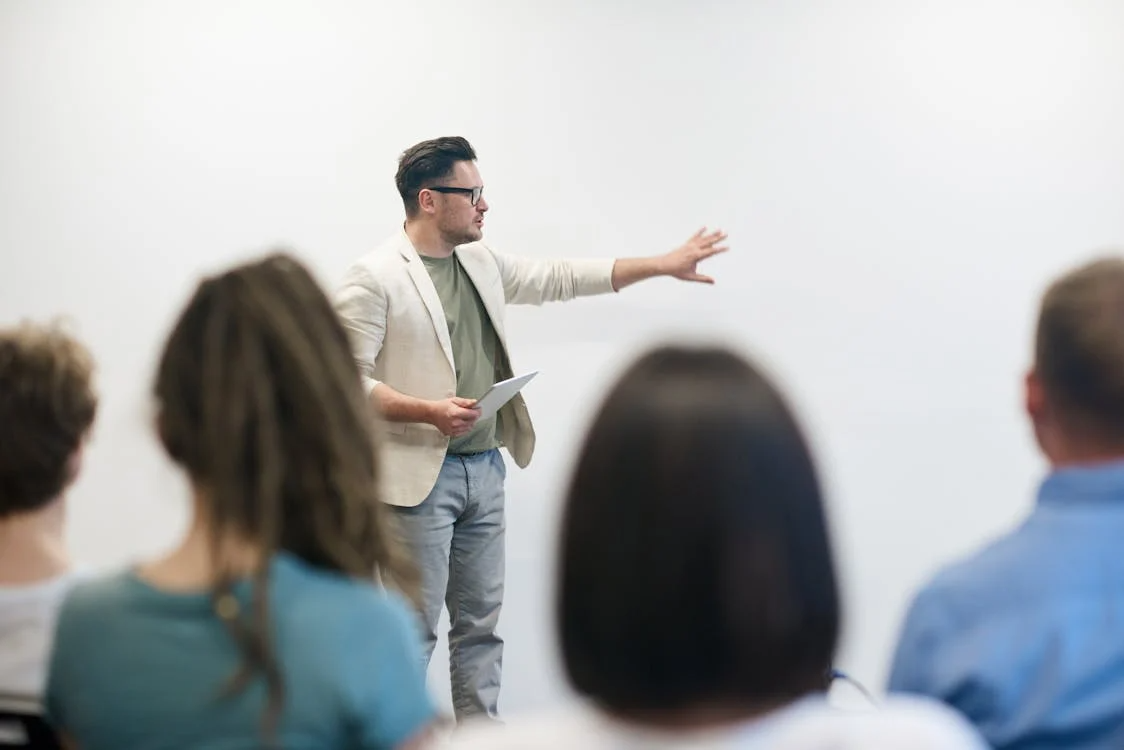 Man directing lesson with blurred crowd in foreground